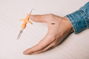 hand, microchip and syringe used for implanting